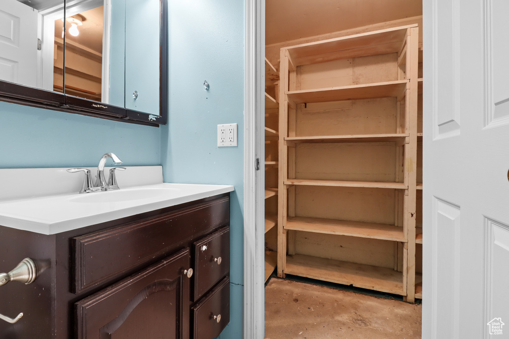 Bathroom with unfinished concrete floors and vanity