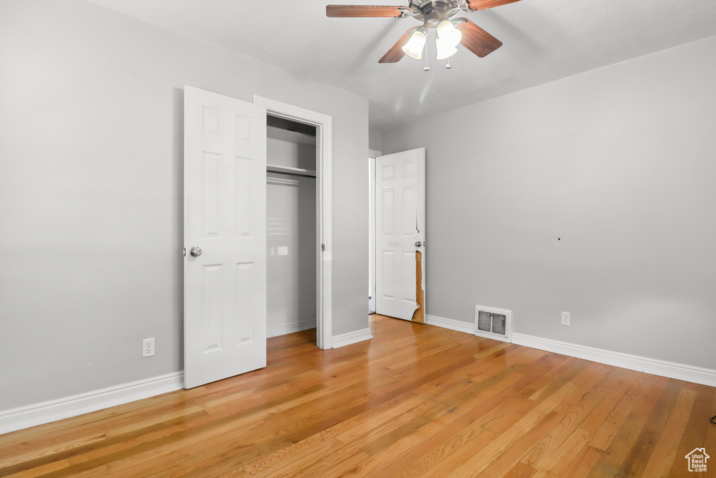 Unfurnished bedroom with light wood-style flooring, a closet, and ceiling fan