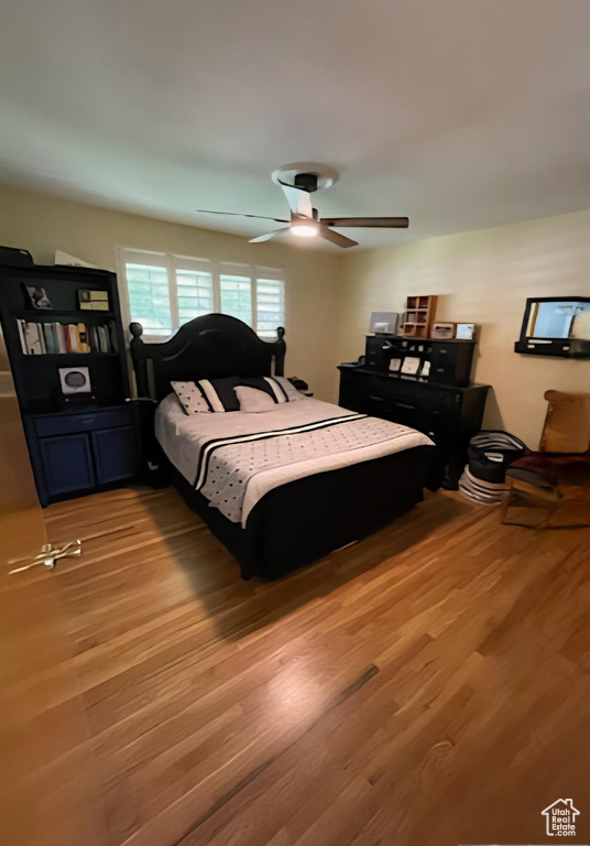 Bedroom with light wood-style floors and a ceiling fan
