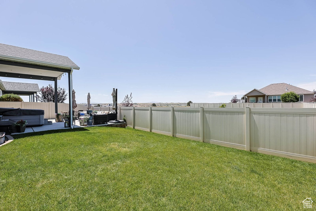 Fenced backyard featuring a hot tub, outdoor lounge area, and a patio area