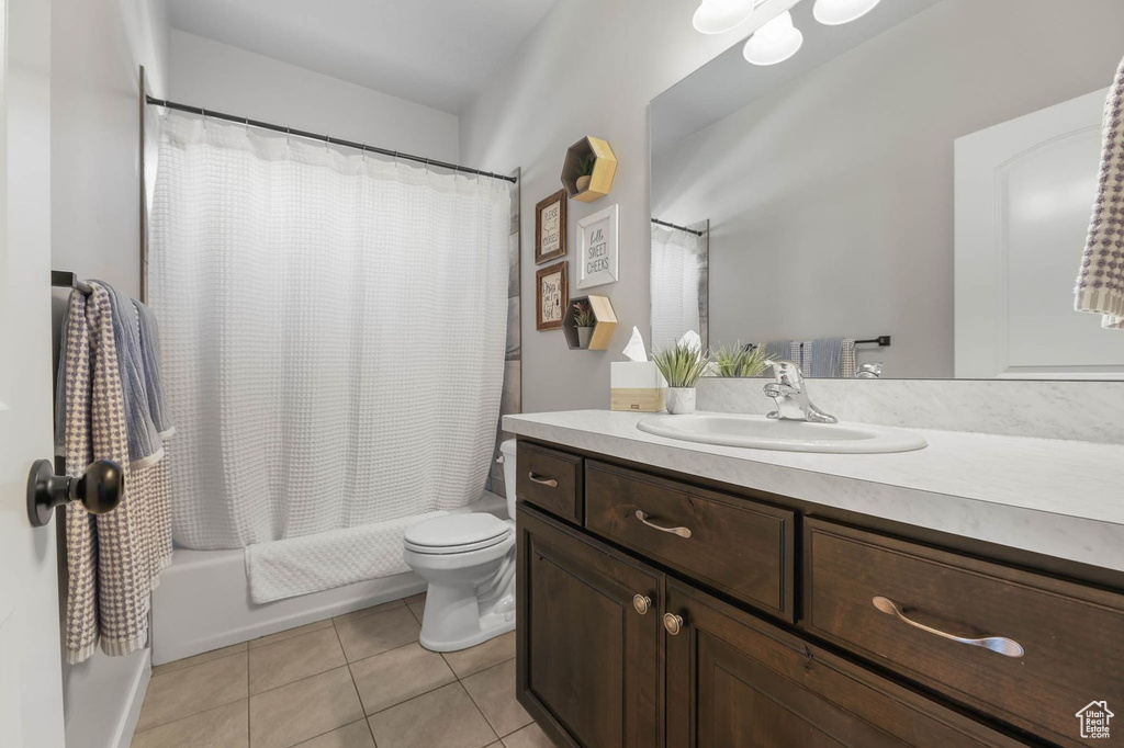 Bathroom with vanity, tile patterned floors, and shower / bath combo with shower curtain