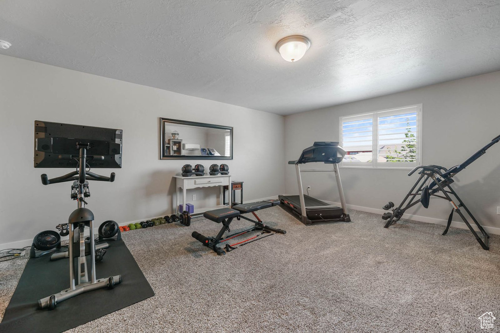 Exercise area featuring a textured ceiling and carpet