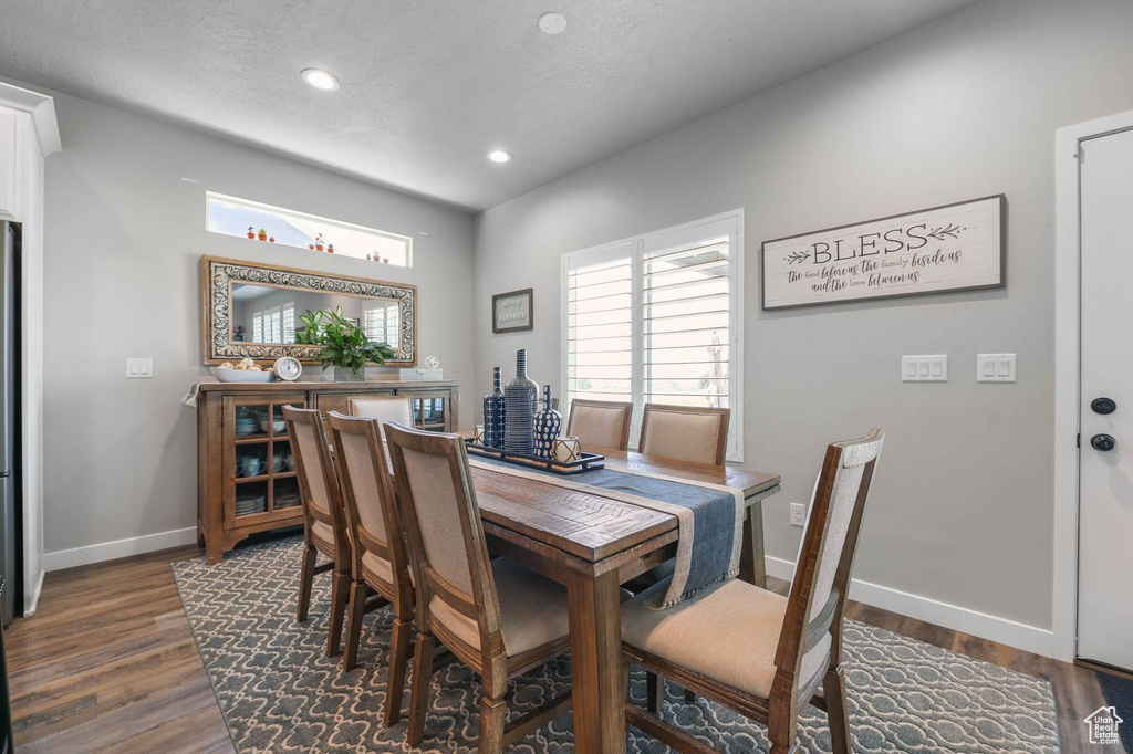 Dining area with healthy amount of natural light, dark wood finished floors, and recessed lighting