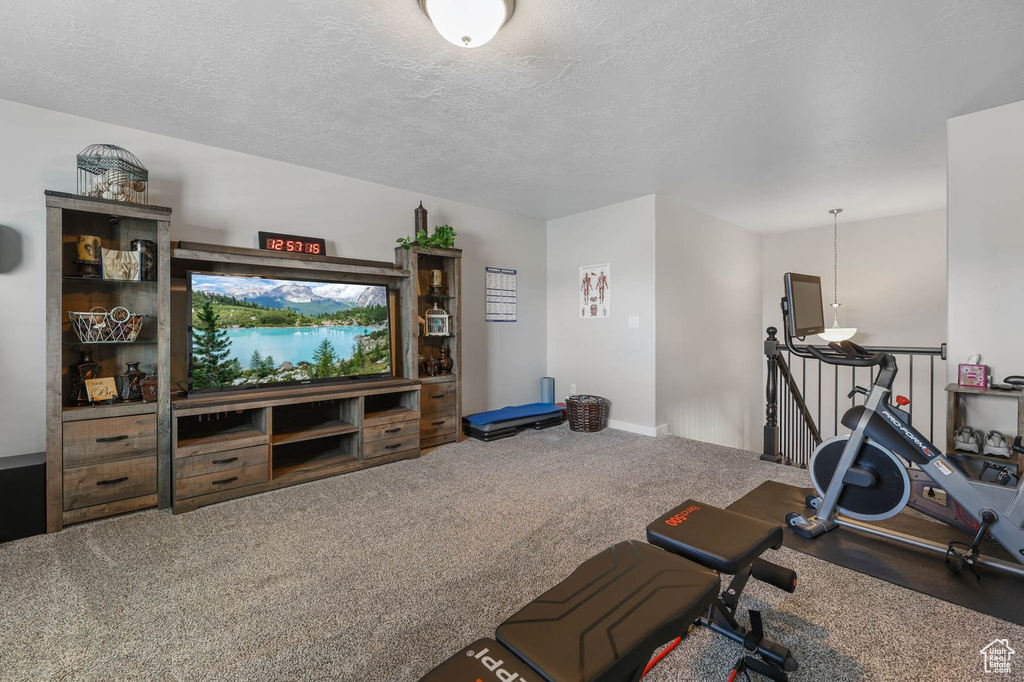 Exercise area featuring carpet and a textured ceiling