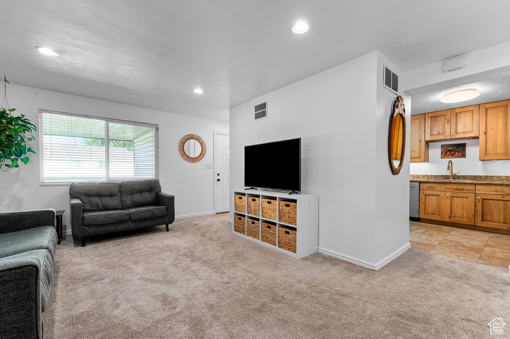 Living area with light carpet and recessed lighting