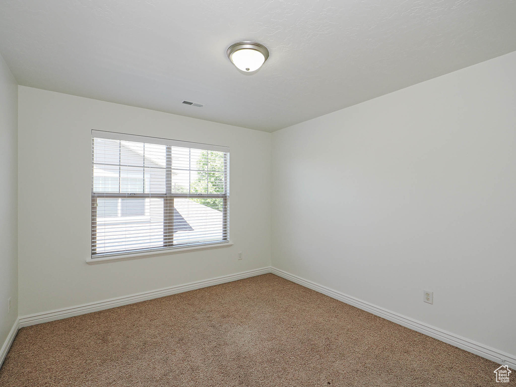 Empty room featuring carpet flooring and baseboards