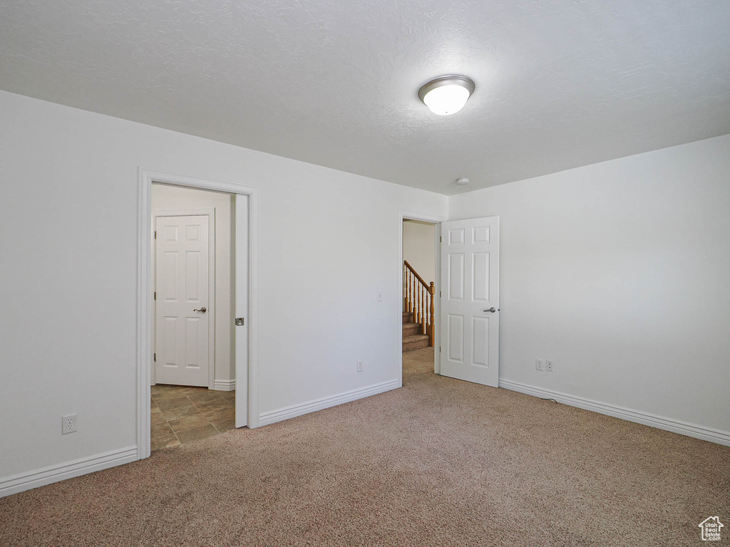 Unfurnished bedroom with carpet flooring and baseboards
