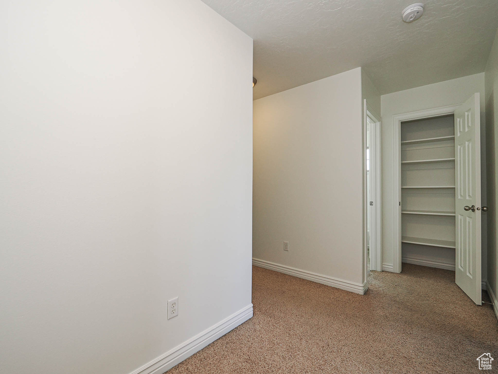 Unfurnished bedroom featuring carpet flooring and baseboards