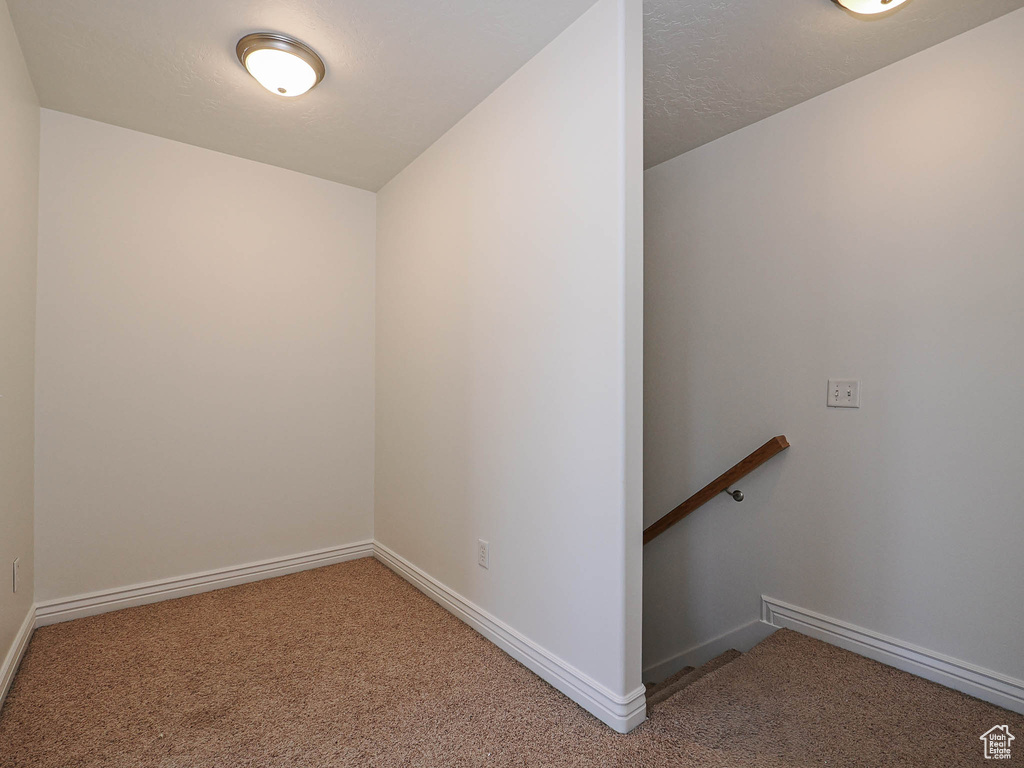 Carpeted spare room featuring baseboards