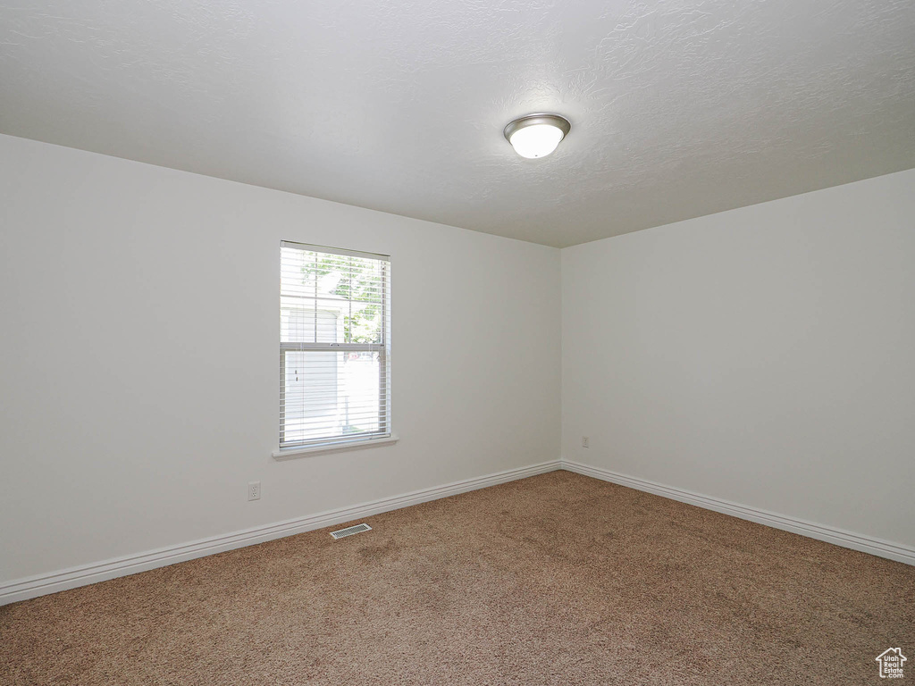 Carpeted empty room featuring baseboards