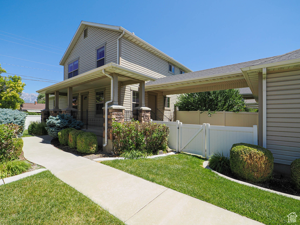 View of property exterior featuring a gate and a porch