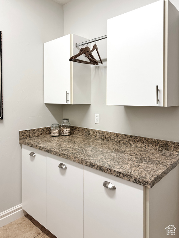 Kitchen with white cabinetry, dark countertops, and light tile patterned flooring
