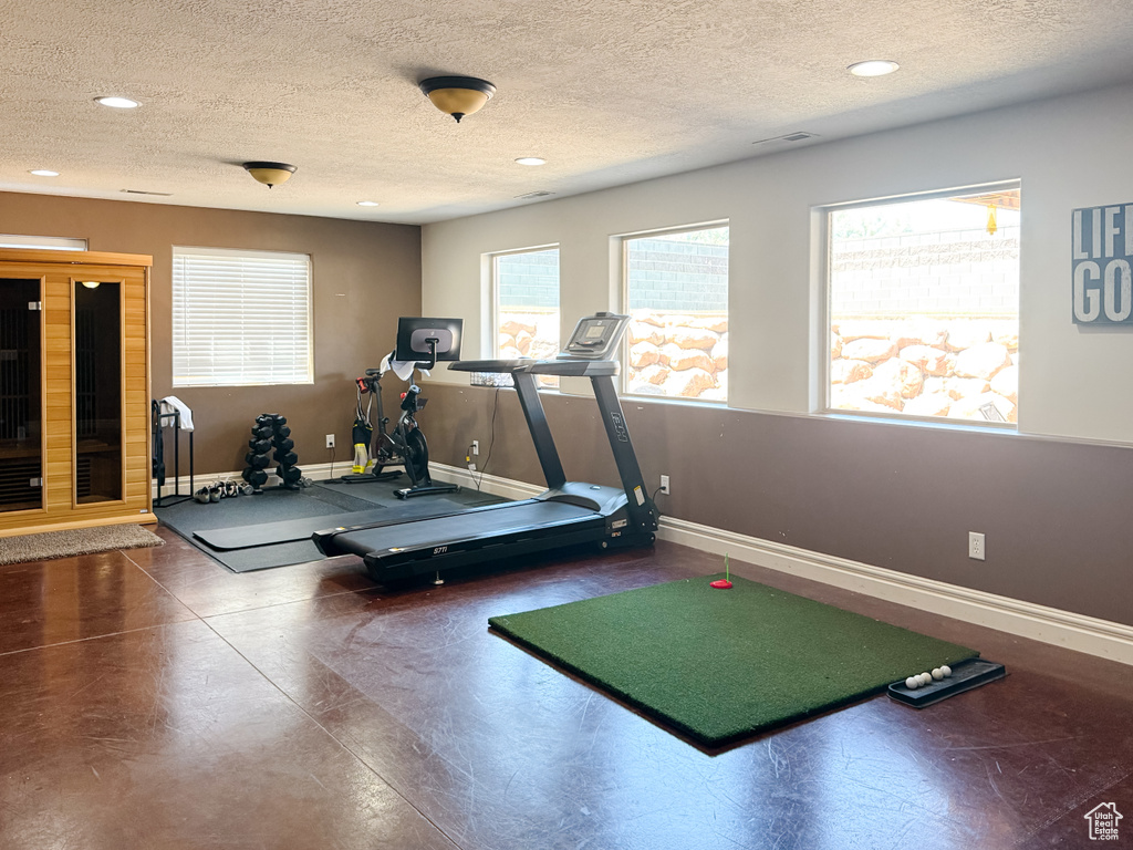 Workout room with a textured ceiling and recessed lighting