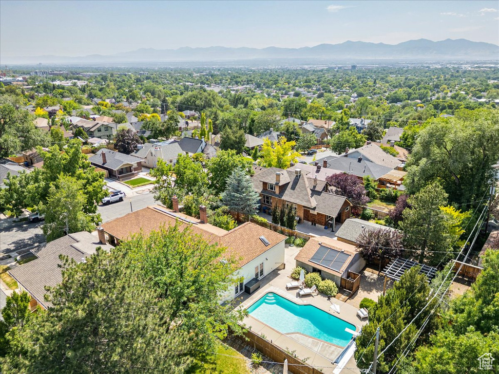 Aerial view of residential area featuring mountains and a pool