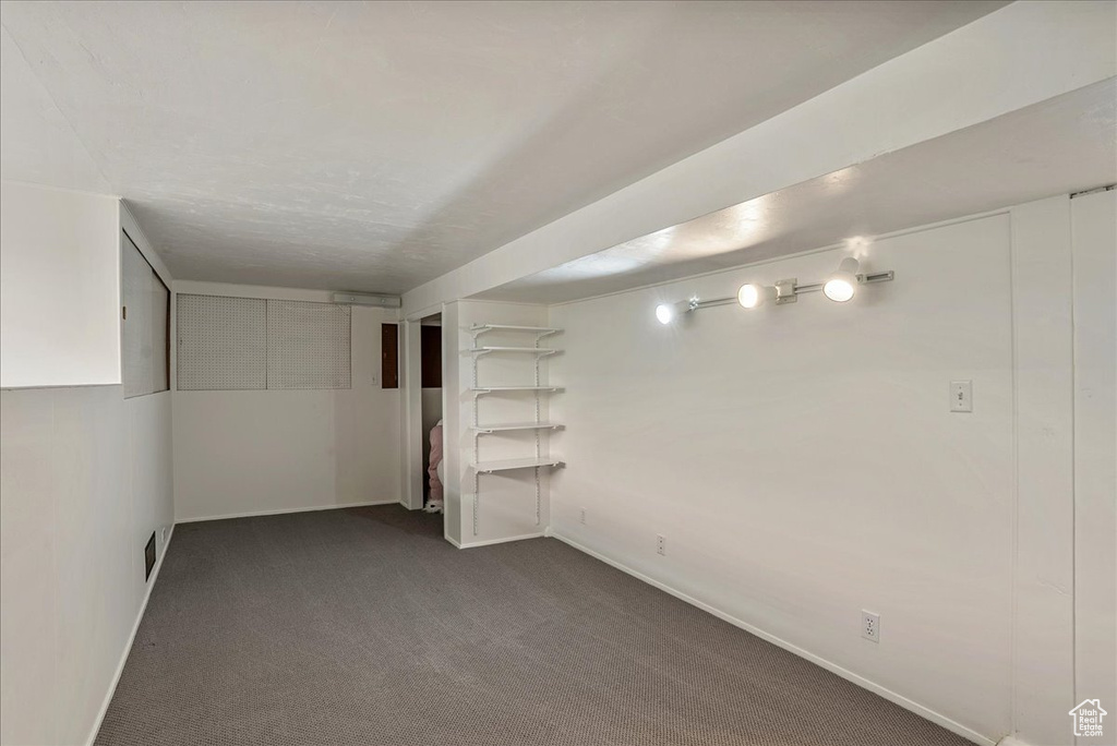 Finished basement featuring dark carpet and baseboards