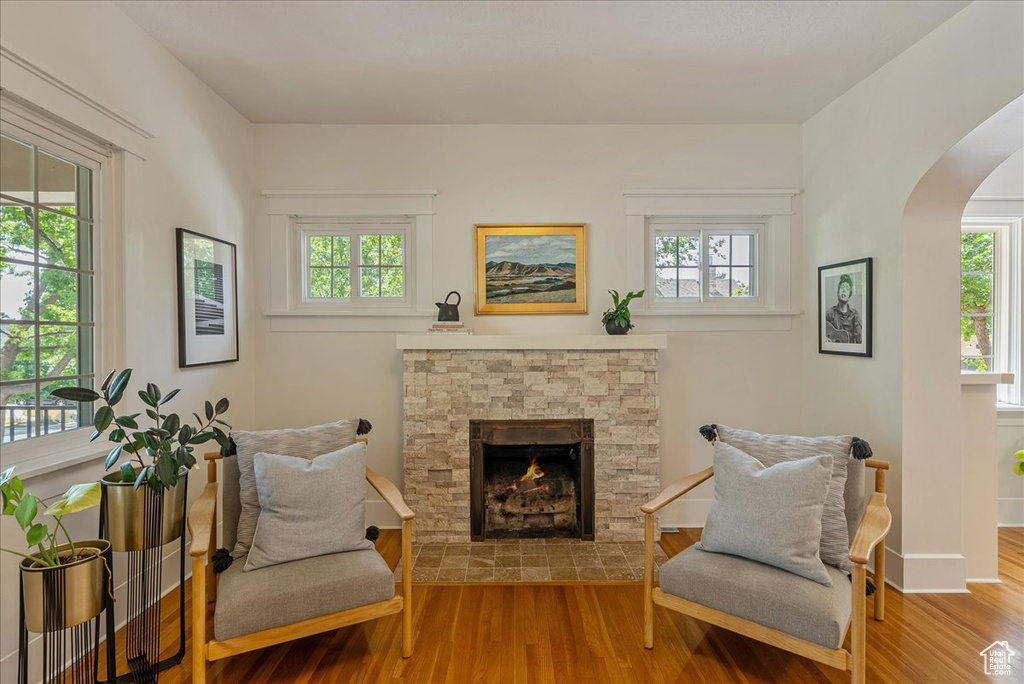 Sitting room with wood finished floors, plenty of natural light, and arched walkways