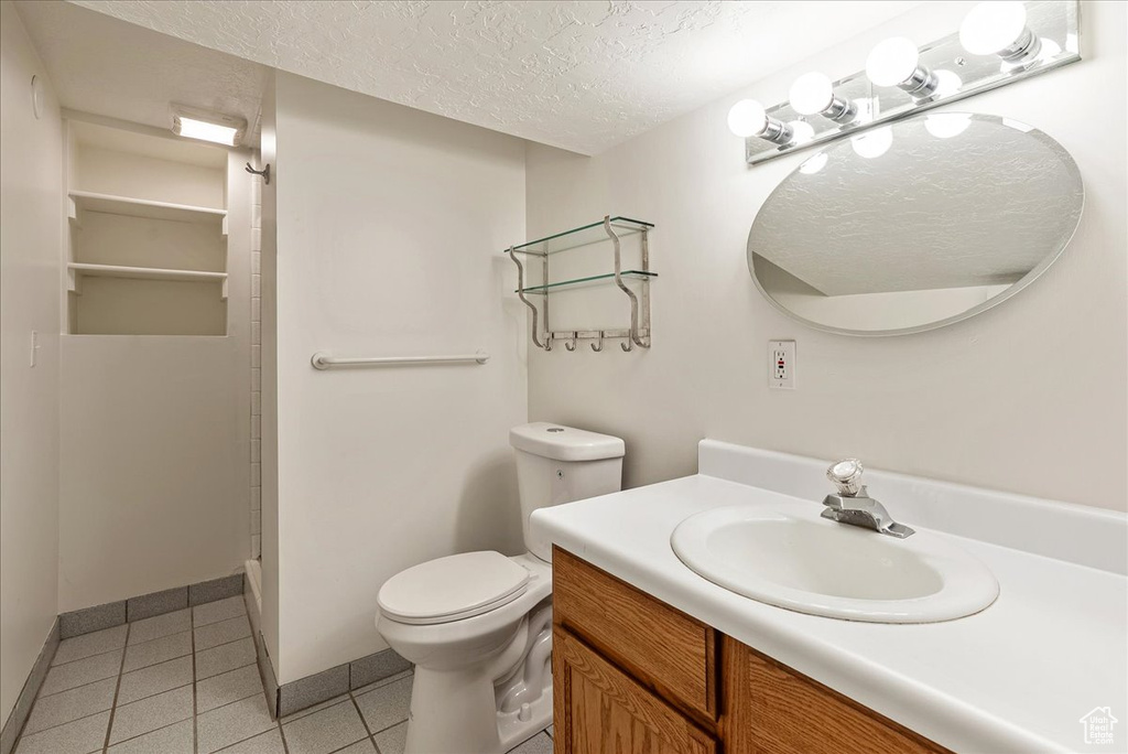 Bathroom featuring a textured ceiling, vanity, and tile patterned flooring