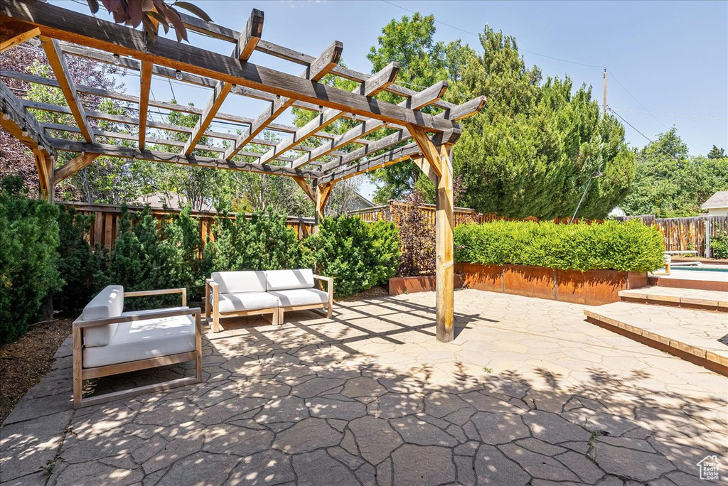 Fenced backyard featuring an outdoor hangout area, a patio, and a pergola