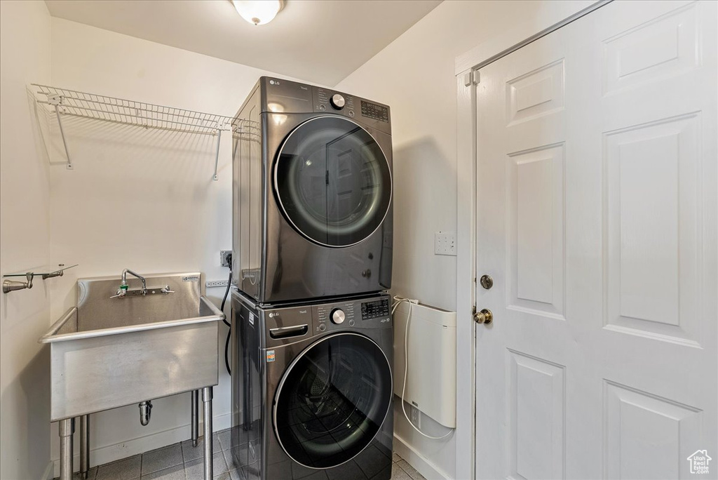 Laundry area featuring stacked washer / dryer and baseboards
