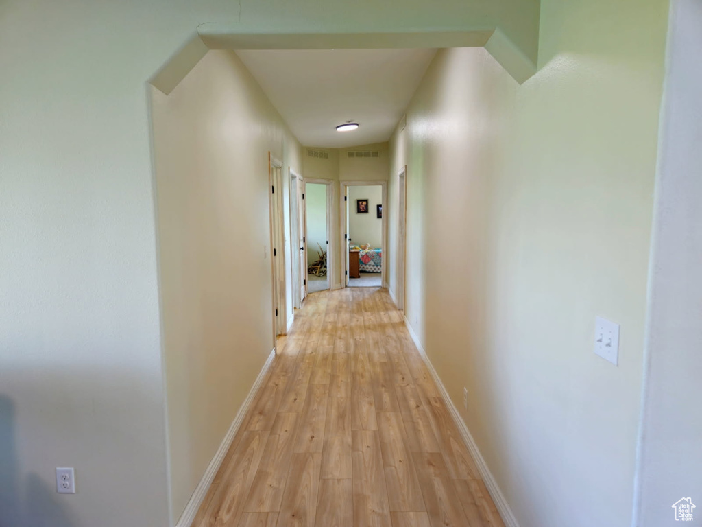 Corridor featuring light wood finished floors and baseboards