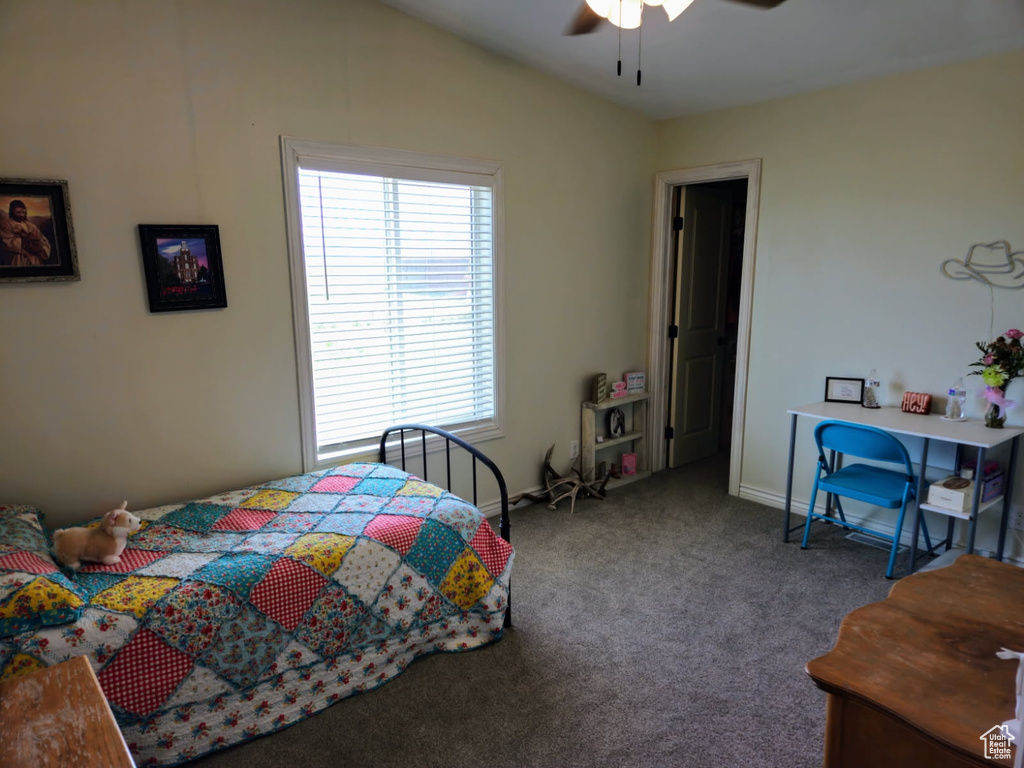 Carpeted bedroom with multiple windows, lofted ceiling, and ceiling fan