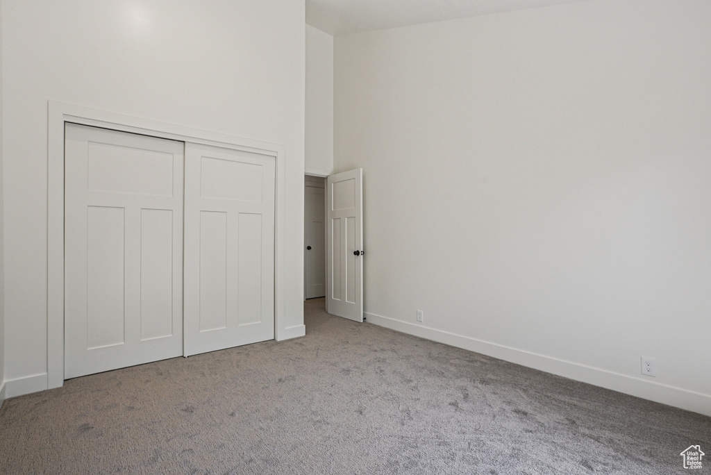 Unfurnished bedroom featuring carpet flooring and a closet