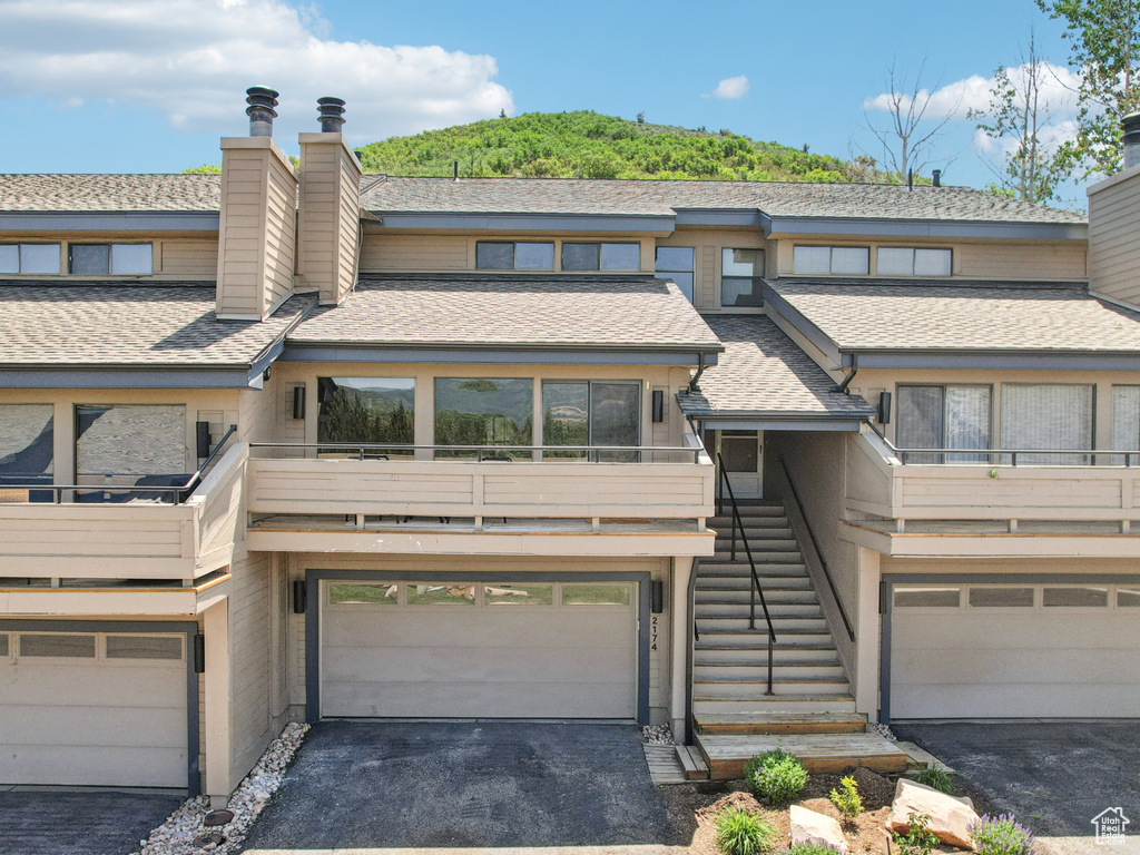 Multi unit property with a chimney, driveway, and stairway