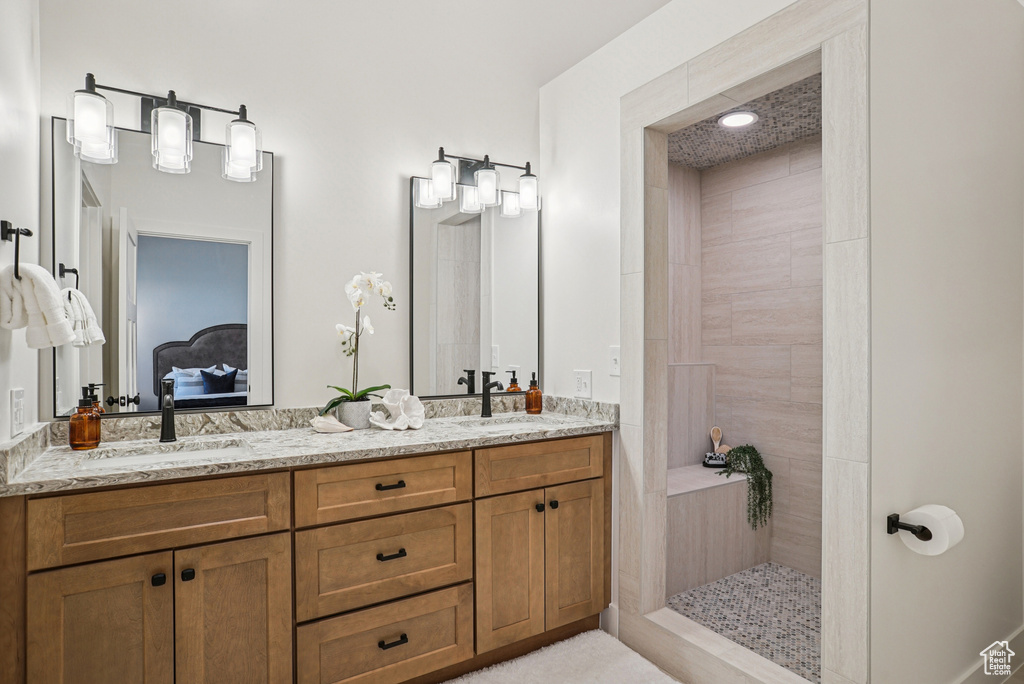 Full bathroom with double vanity, ensuite bathroom, and walk in shower