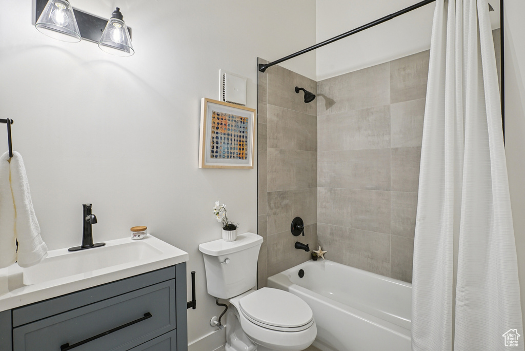 Bathroom featuring shower / bathtub combination with curtain and vanity