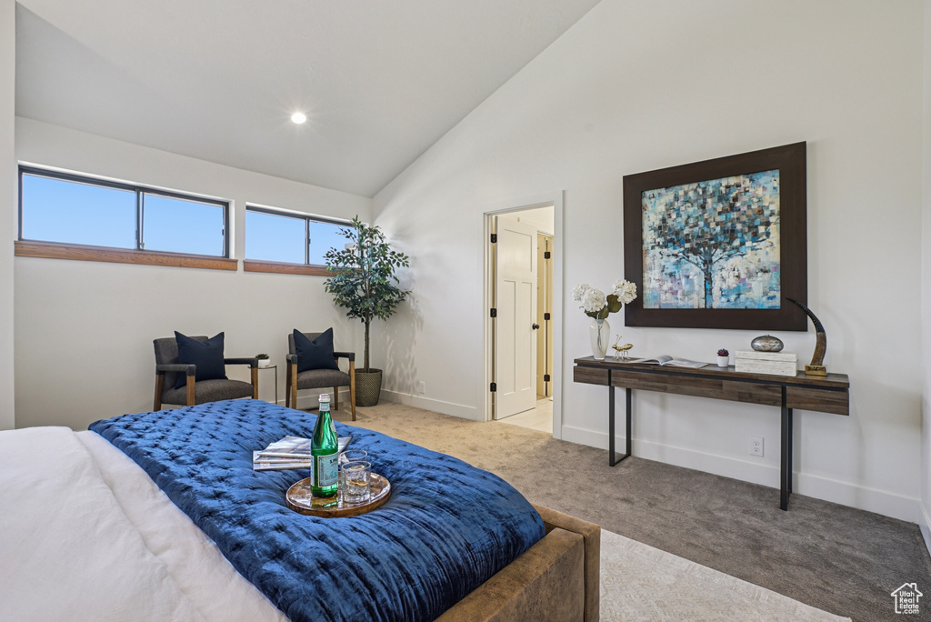 Carpeted bedroom featuring baseboards and high vaulted ceiling