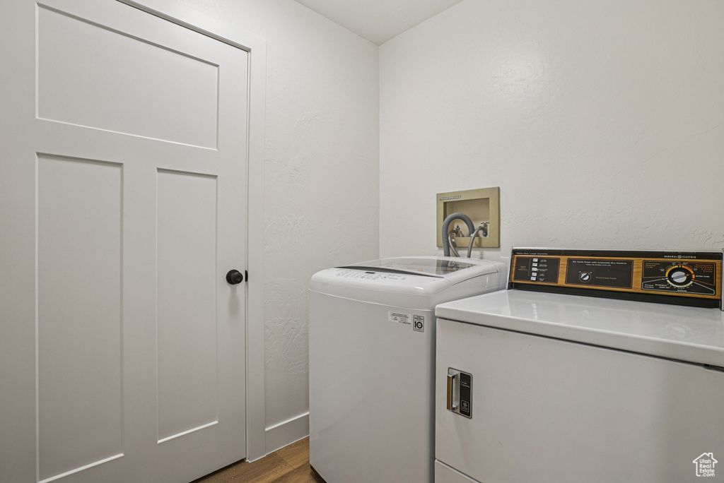 Laundry area with independent washer and dryer and dark wood-style floors