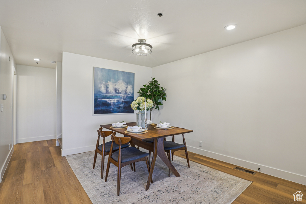 Dining room with wood finished floors and recessed lighting