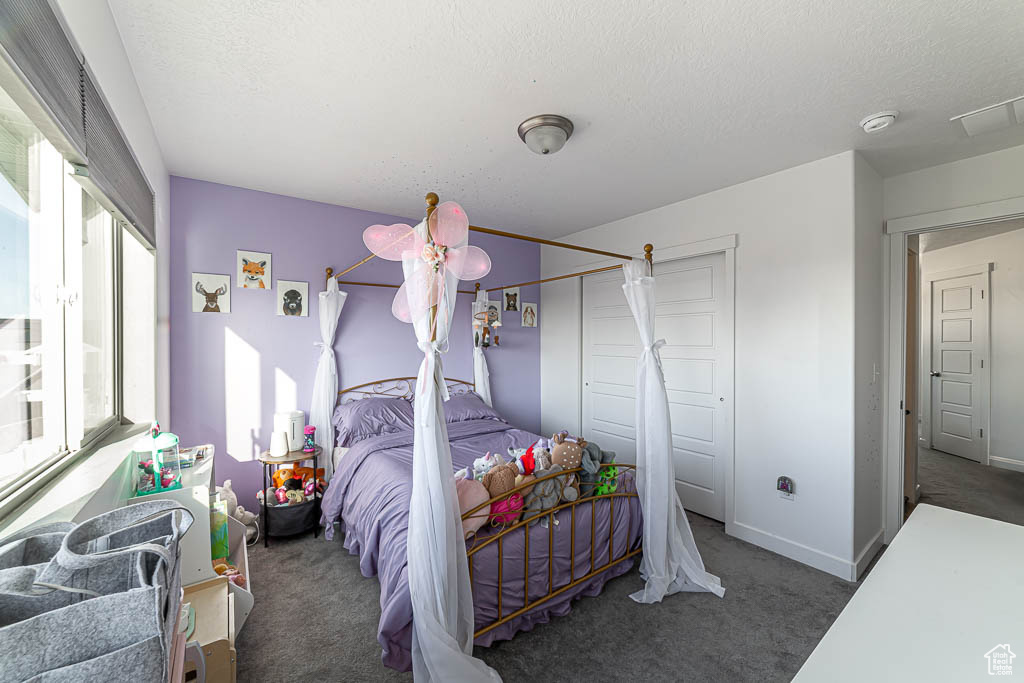 Bedroom featuring carpet and a textured ceiling