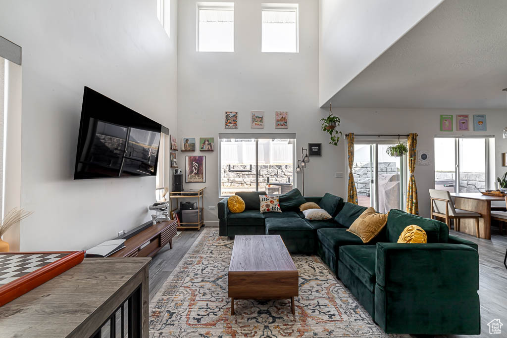 Living room with wood finished floors and a towering ceiling