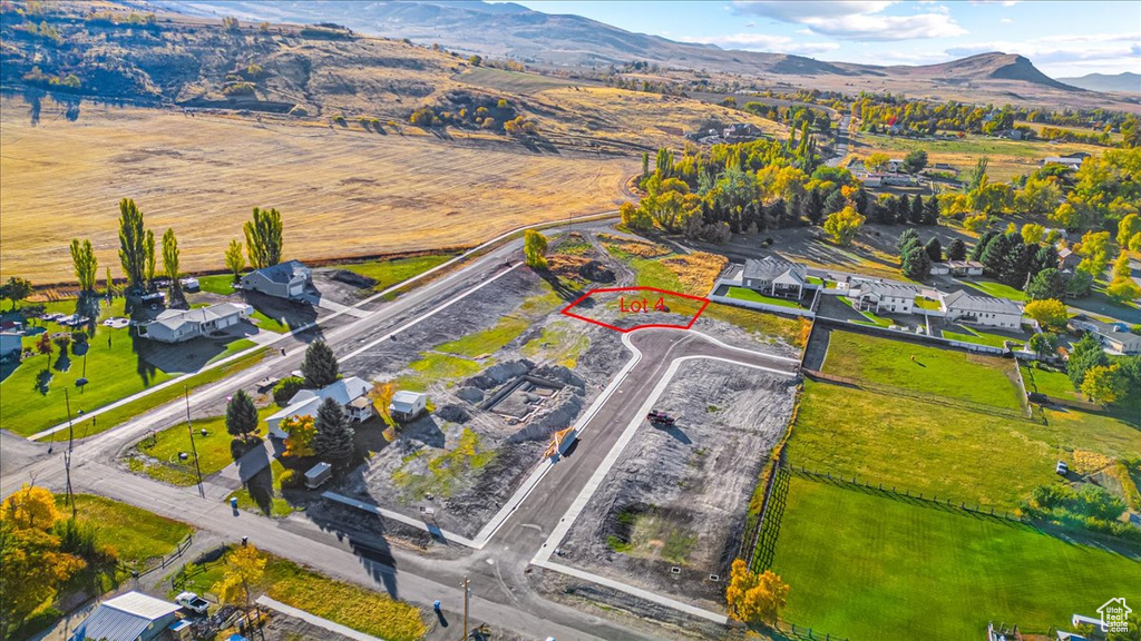 Aerial view of property and surrounding area with property parcel outlined and a mountainous background