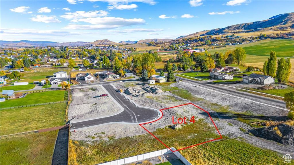 Aerial perspective of suburban area with property boundaries highlighted and a mountain backdrop