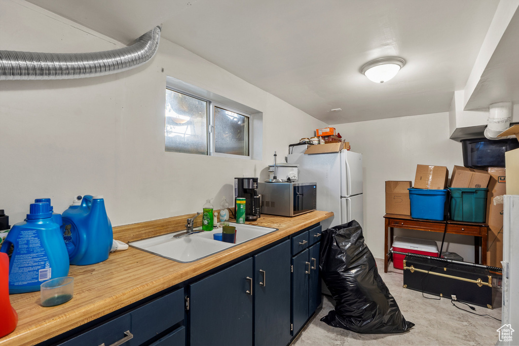 Kitchen featuring blue cabinets and stainless steel microwave