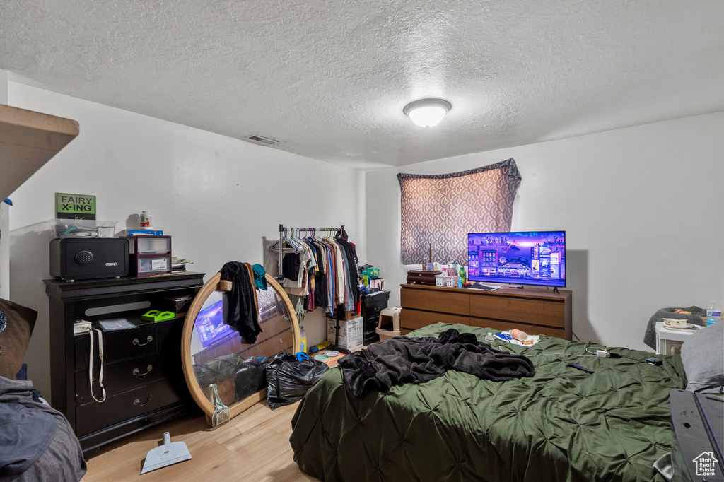 Bedroom featuring wood finished floors and a textured ceiling