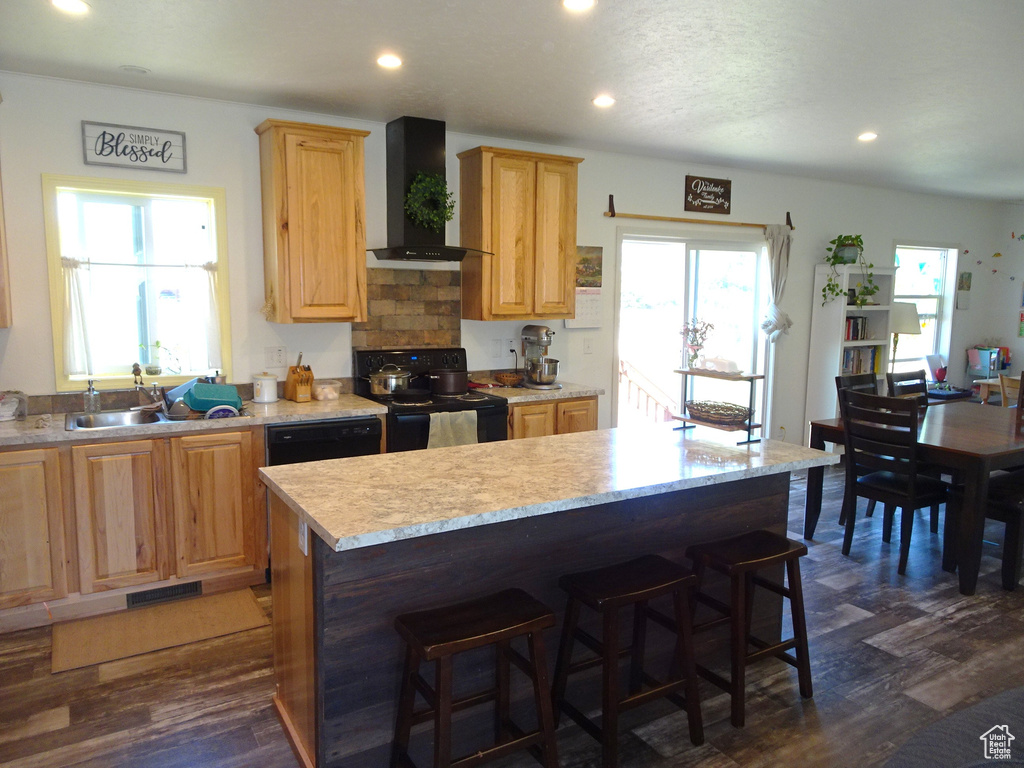 Kitchen featuring wall chimney range hood, black electric range, dark wood-style flooring, recessed lighting, and a center island