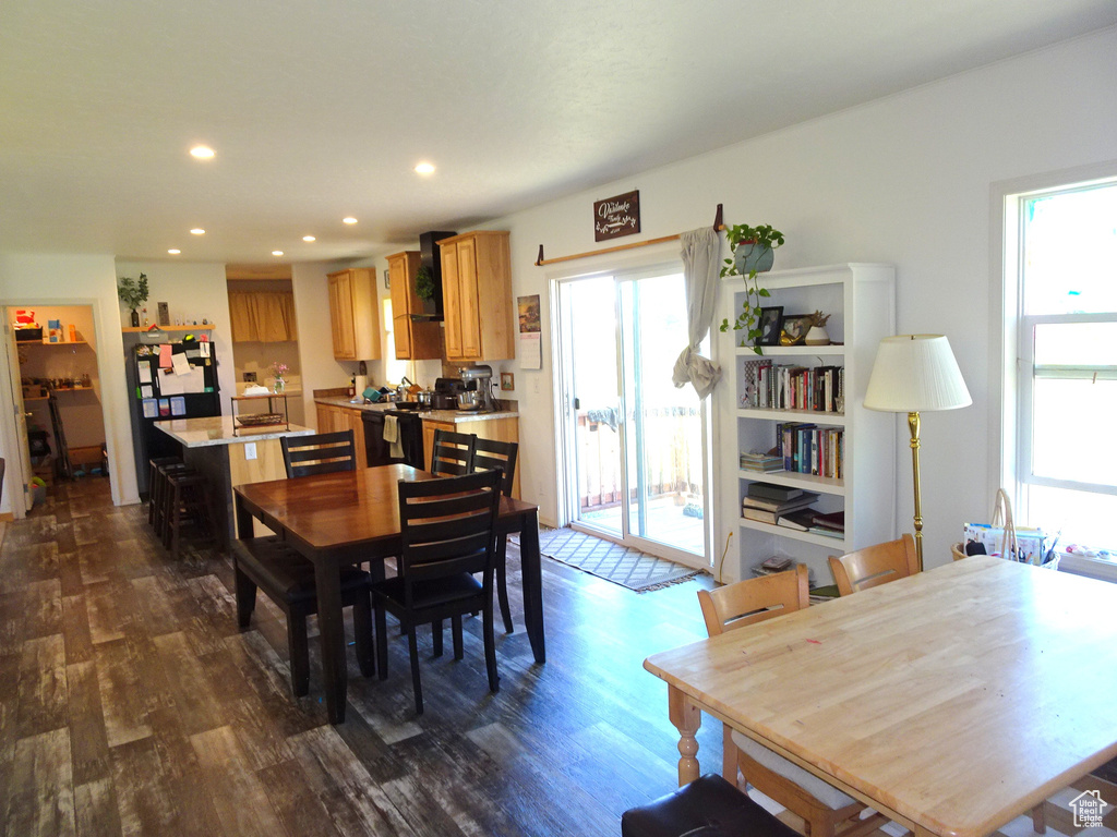 Dining area with dark wood-type flooring, healthy amount of natural light, and recessed lighting