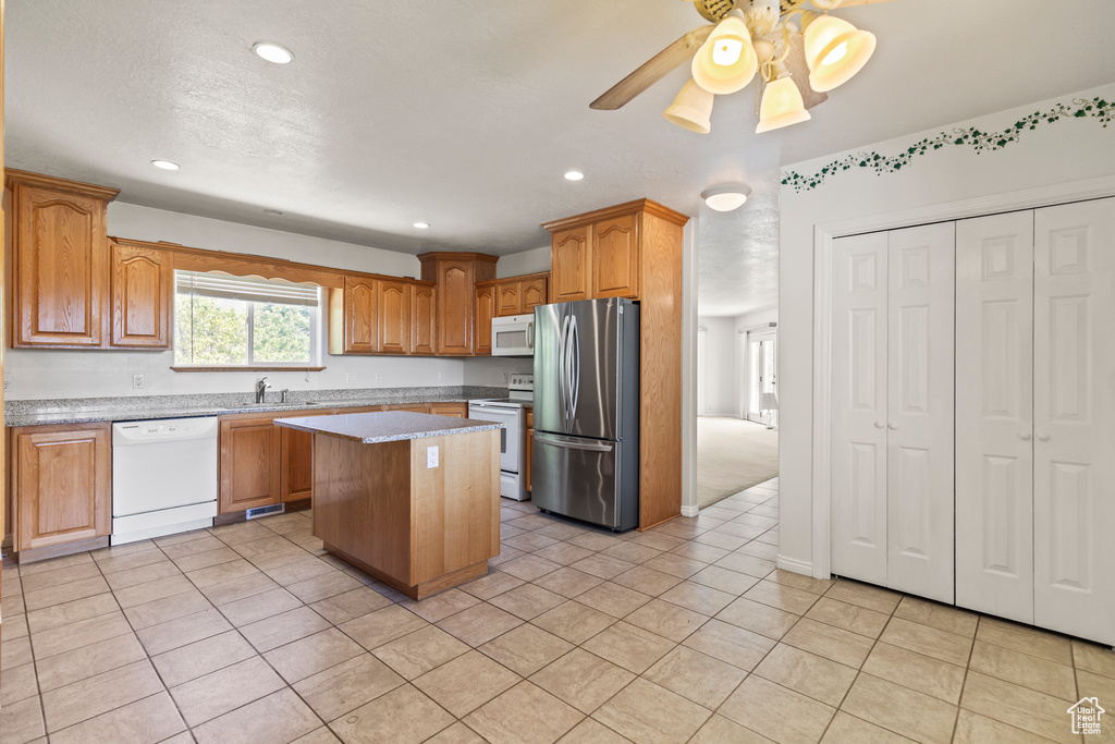 Kitchen with white appliances, a center island, light tile patterned flooring, recessed lighting, and a ceiling fan