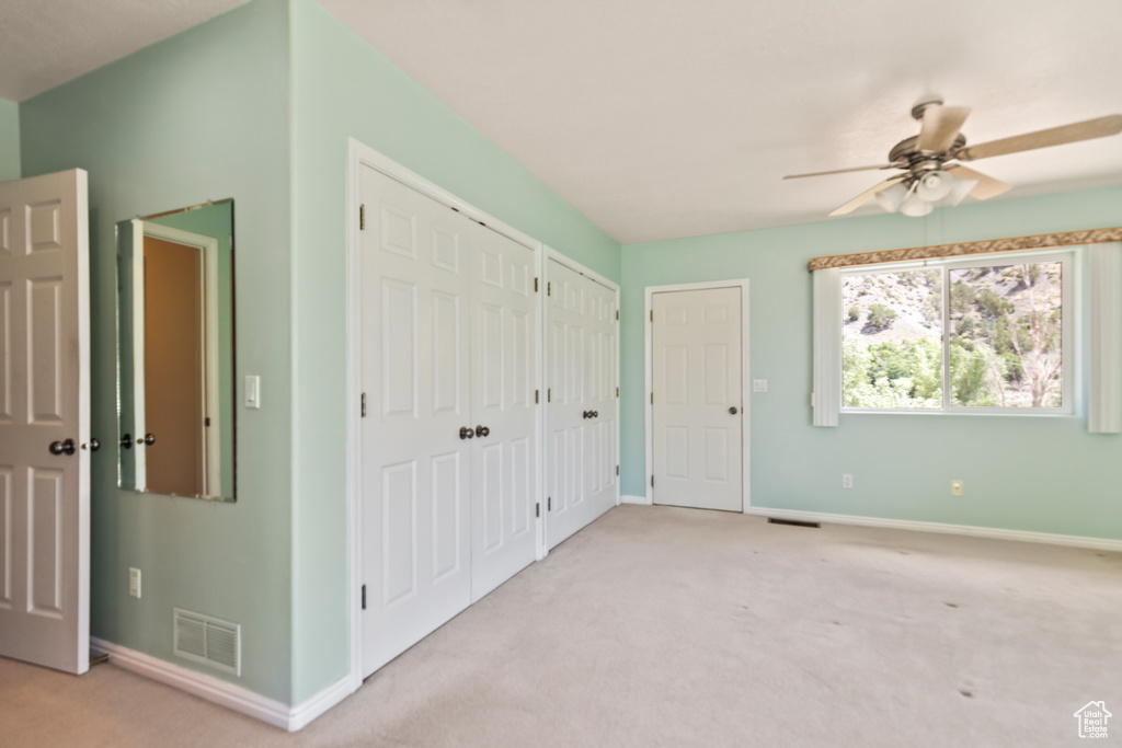 Unfurnished bedroom featuring two closets and light carpet