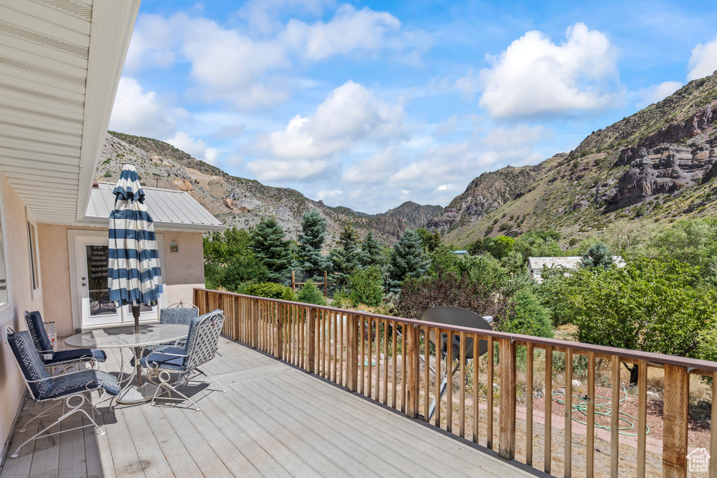 Wooden deck with a mountain view and outdoor dining space