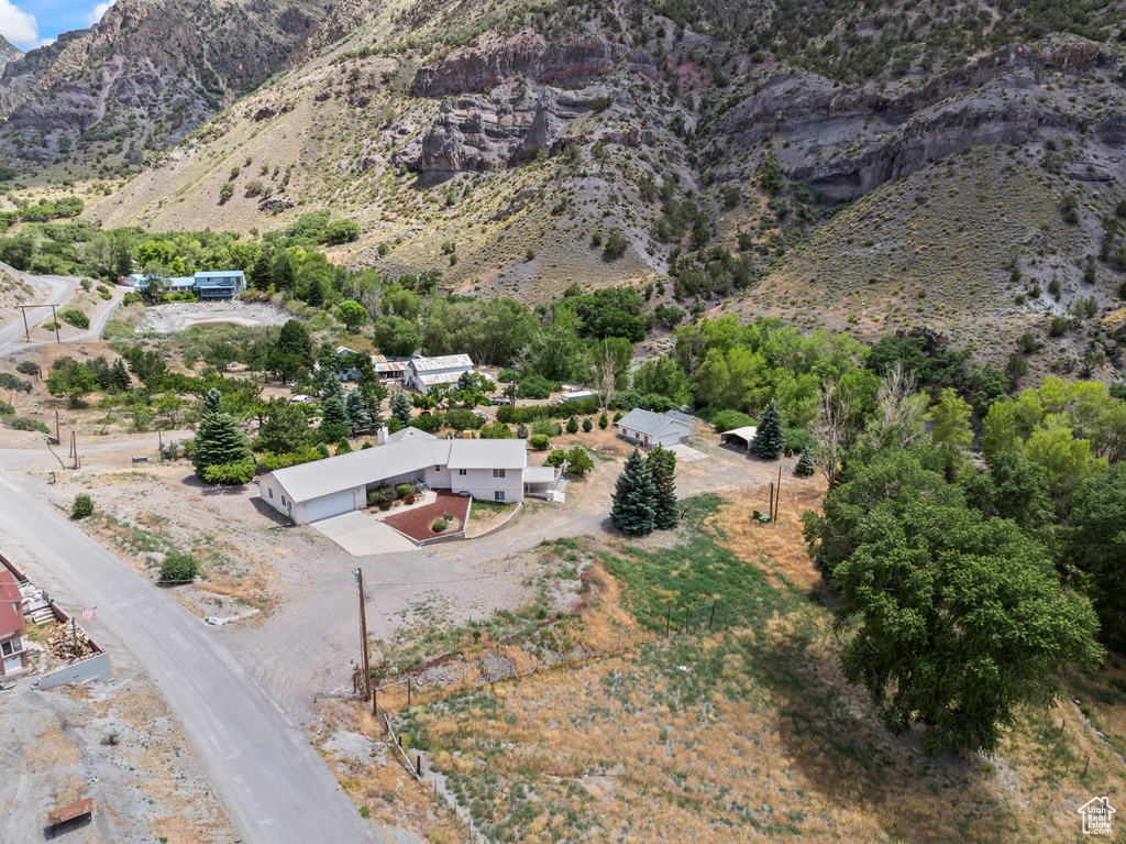 Aerial view of property and surrounding area featuring a mountainous background