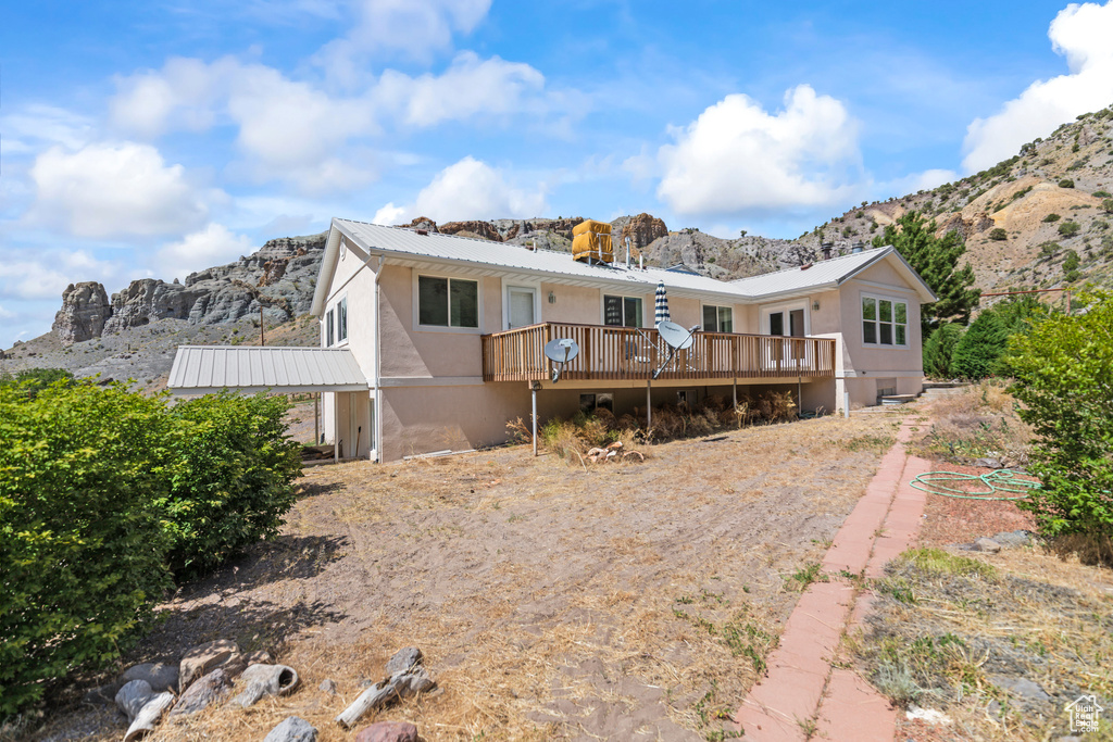 Rear view of house featuring a deck with mountain view and a metal roof