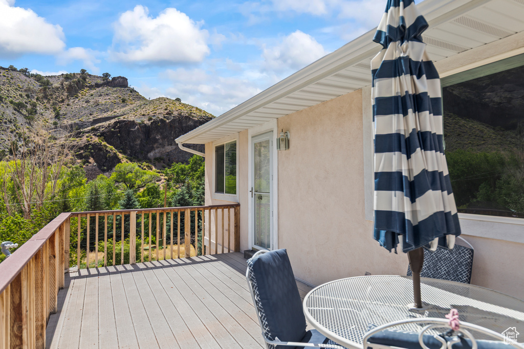 Wooden deck with outdoor dining space and a mountain view