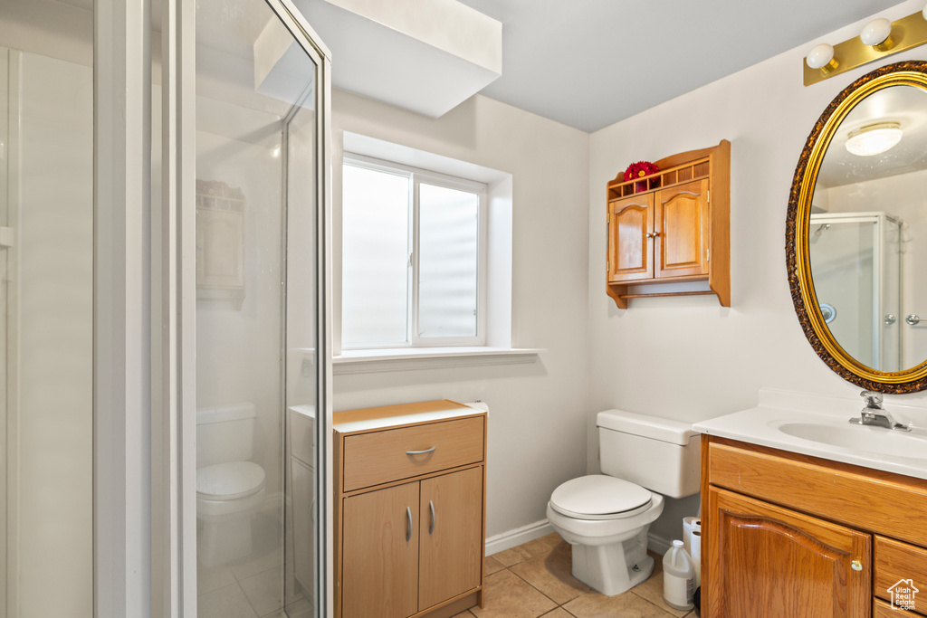Full bathroom with a shower stall, vanity, and tile patterned floors