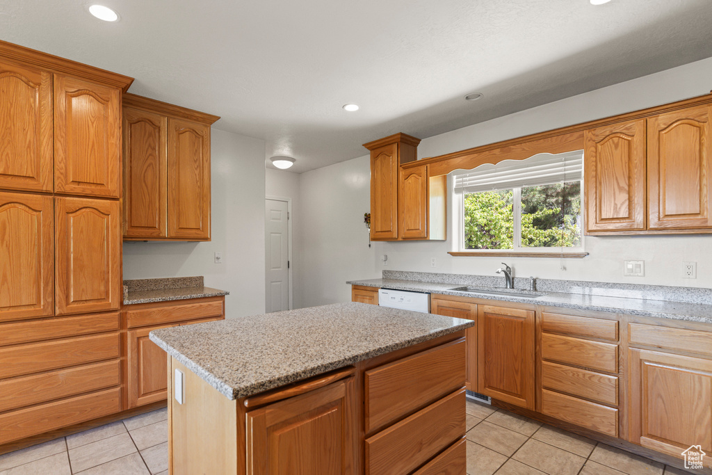 Kitchen with light tile patterned floors, light stone counters, recessed lighting, a center island, and white dishwasher