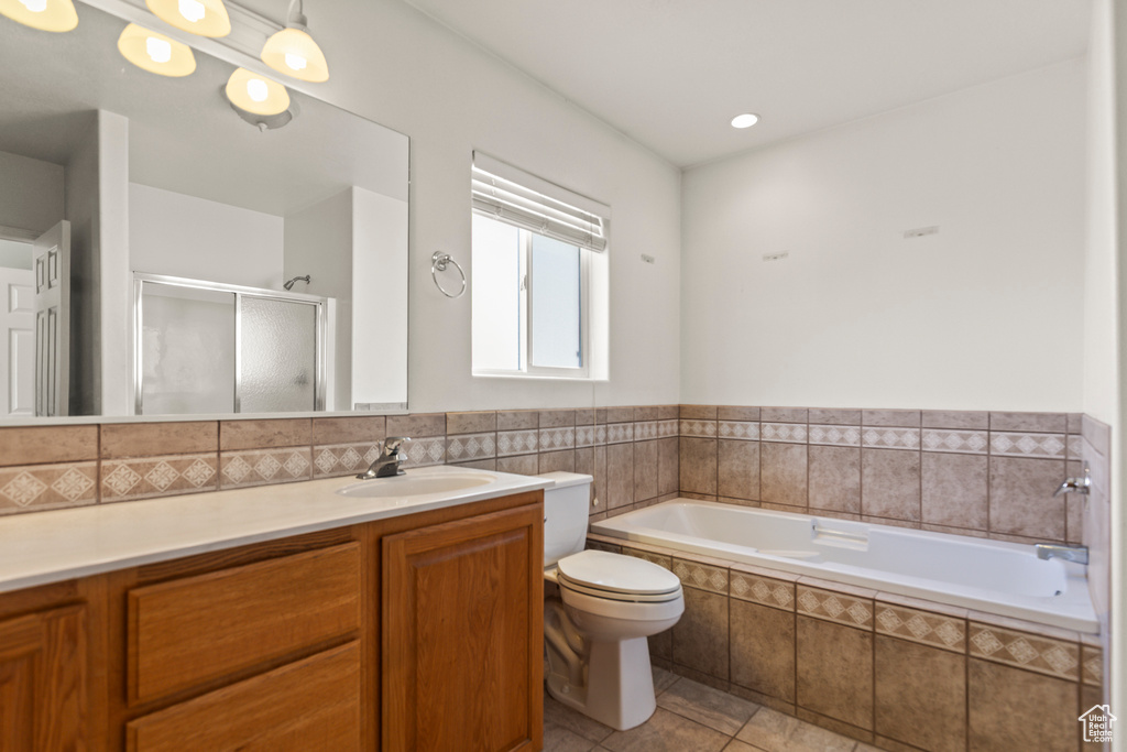 Bathroom featuring vanity, a bath, tile patterned floors, and a stall shower