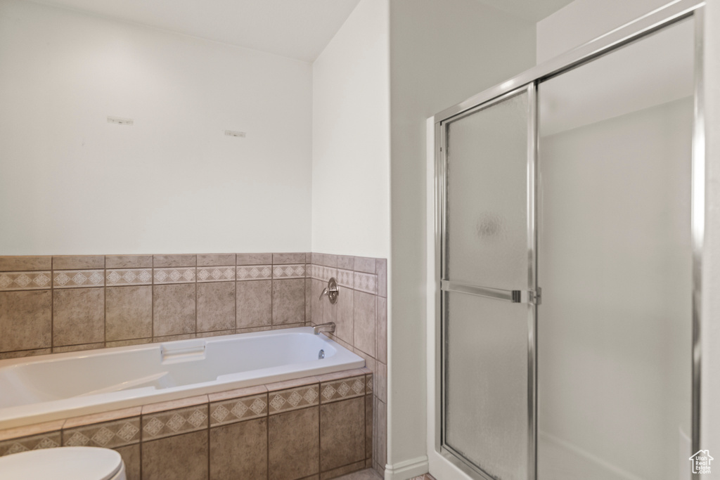 Bathroom with a shower stall and a bath
